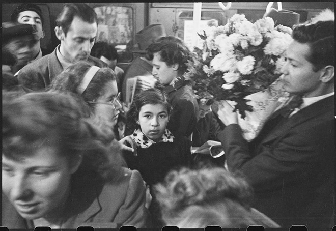 Stanley Kubrick. Life and Love on the New York City Subway. Man carrying flowers on a crowded subway. 1946. Museum of the City of New York. X2011.4.10292.37C