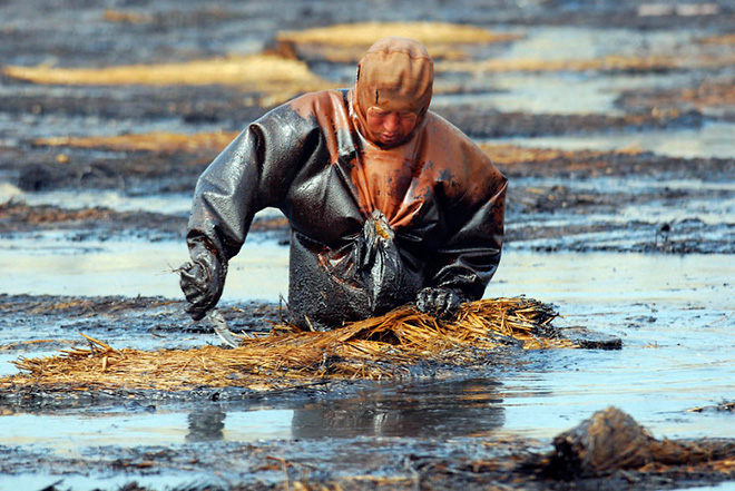 A labourer cleans up oil at the oil spill site near Dalian port, Liaoning province July 23, 2010 A labourer cleans up oil at the oil spill site near Dalian port, Liaoning province July 23, 2010
