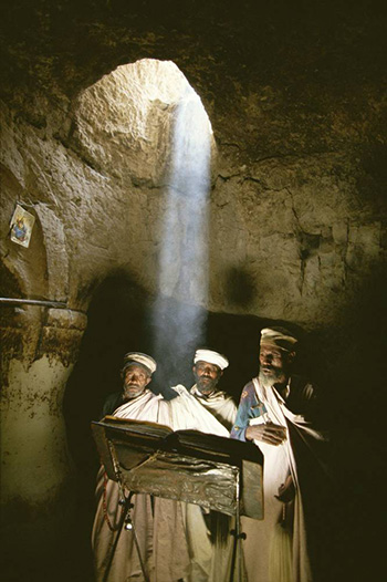 Kazuyoshi Nomachi, Etiopia -Un gruppo di sacerdoti prega nella chiesa di Abuna Aron poco dopo mezzogiorno, quando da un oculo della volta i raggi del sole scendono a perpendicolo nella chiesa scavata nella roccia Nei pressi di Lalibela, Etiopia 1996 Kazuyoshi Nomachi, Etiopia -Un gruppo di sacerdoti prega nella chiesa di Abuna Aron poco dopo mezzogiorno, quando da un oculo della volta i raggi del sole scendono a perpendicolo nella chiesa scavata nella roccia Nei pressi di Lalibela, Etiopia 1996
