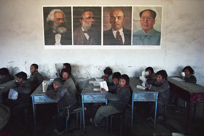 Kazuyoshi Nomachi, Tibet - Una classe di scuola primaria con i ritratti di quattro “padri del comunismo” appesi al muro Tibet, Cina 1991 Kazuyoshi Nomachi, Tibet - Una classe di scuola primaria con i ritratti di quattro “padri del comunismo” appesi al muro Tibet, Cina 1991