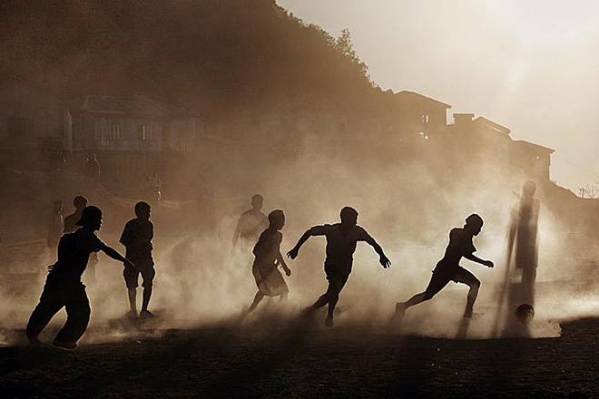 ©Timothy Allen - Mizo boys playing football at sunset, Sangau, Mizoram, North East states, India