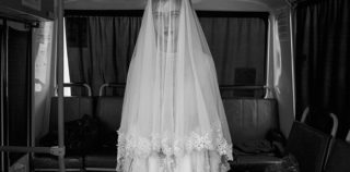 ©Davide Monteleone - Spasibo. Republic of Chechnya, Russia, 03/2013. Rada, 14 years old is trying a wedding dress designed by her sister, inside a bus during the rehearsal for the shooting of a movie on Chechen deportation. Davide Monteleone – Spasibo