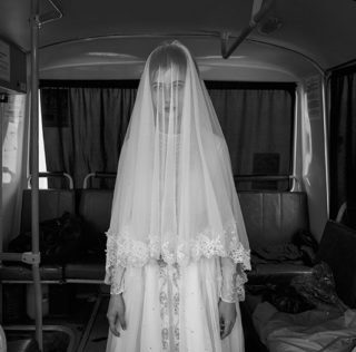 ©Davide Monteleone - Spasibo. Republic of Chechnya, Russia, 03/2013. Rada, 14 years old is trying a wedding dress designed by her sister, inside a bus during the rehearsal for the shooting of a movie on Chechen deportation. Davide Monteleone – Spasibo