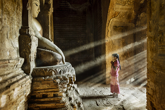 Bagan, Myanmar. Stefano Pensotti, Italy. Overall winner, Travel Photographer of the Year 2018. (Prayer time in one of little temples in the plain of Bagan - a young girl stops on her way to school). (Photo: Stefano Pensotti/www.tpoty.com)