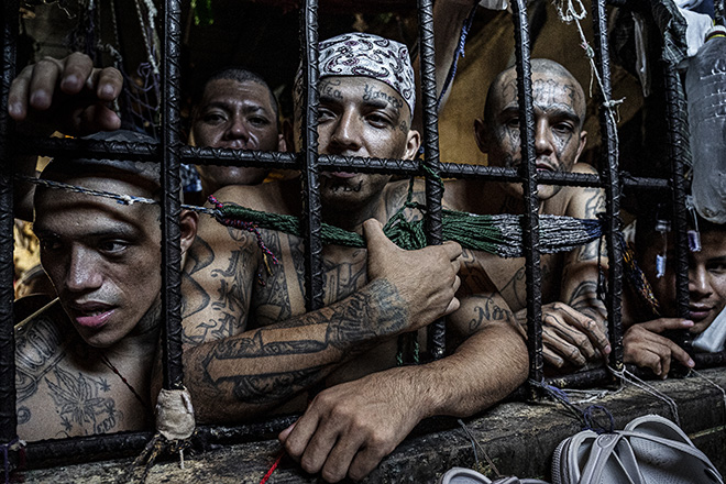 Tariq Zaidi (United Kingdom) - Title: Inmates look out of a cell. Title of the series: Sin Salida (No Way Out). Inmates look out of a cell in the Penal Center of Quezaltepeque. El Salvador. November 2018. Merit Award: All About Photo Awards 2022 - The Mind's Eye