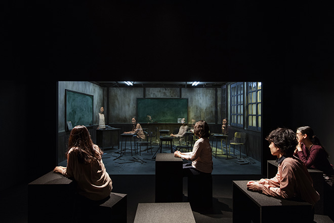 Leandro Erlich - Classroom (2017). Two rooms of identical dimensions, wood, windows, desk, chairs, door, glass, lights, blackboard, school. supplies and other classroom decorations, and black boxes. Dimensions variable
