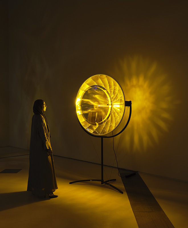 Eye see you, 2006. Stainless steel, aluminium, colour-effect filter glass, monofrequency bulb. 230 x 120 x 110 cm. Installation view: Olafur Eliasson: The curious desert, National Museum of Qatar, Doha, 2023. Photo: Anders Sune Berg. Courtesy of the artist; neugerriemschneider, Berlin; Tanya Bonakdar Gallery, New York / Los Angeles.