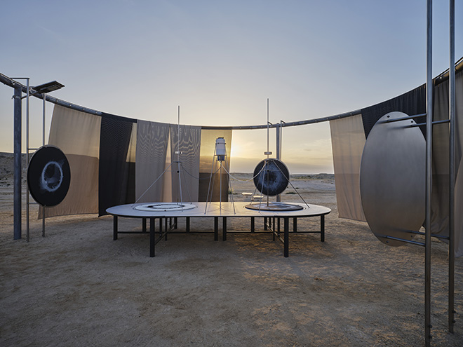 Saltwater-drawing observatory, 2023. Galvanized steel, textile (beige, anthracite), solar lamp, solar panel, batteries, stainless steel, aluminium, paint (anthracite), motor, plastic, wood, canvases (black, white), pigmented saltwater (white and black acrylic ink). 380 x 950 x 950 cm. Installation view: Olafur Eliasson: The curious desert, near the Al Thakhira Mangrove in Northern Qatar, 2023. Photo: Anders Sune Berg. Courtesy of the artist; neugerriemschneider, Berlin; Tanya Bonakdar Gallery, New York / Los Angeles.