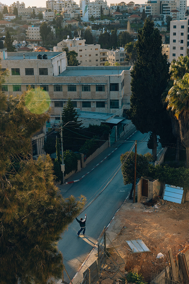 Maen Hammad - LANDING. Aram skateboarding down a street in the occupied West Bank city of Ramallah.