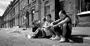 Toby Binder (Germany) - Belfast, Shankill. Girls sitting on the sidewalk of Tennent Street. Series: Wee Mcukers – Youth of Belfast. 1st Place Winner: AAP Magazine #36: Street.