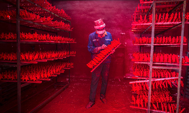 The two men produce 5,000 red snowflakes a day, and get paid around £300 a month. Photograph: China Daily/Reuters