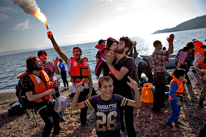  Jacob Ehrbahn - Refugee stream, Lesbos island. A boat with people from Syria and Afghanistan comes ashore on a beach near Eftalou on the Greek island of Lesbos. They’ve had a tough crossing and everyone is incredibly relieved when they finally reach land. Many cry tears of joy, a man lights an emergency flare, and people dance, sing, pray and snap photos of each other with their cell phones. 