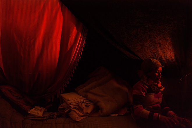 Yiorgios Doukanaris, Home, Calais, France, 2015. An Eritrean refugee woman sitting in her tent in the refugee camp of Calais, France.