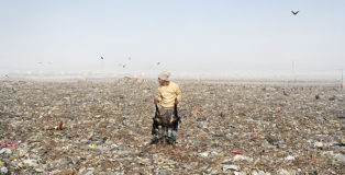 Jim Goldberg (New Haven, USA, 1953). Mezzogiorno di fuoco, discarica di Dhaka, Bangladesh, dalla serie “Open See”, 2007 High Noon, Dhaka Dump, Bangladesh, from the series “Open See”, 2007 Carta stampata dipinta a mano, murale / Hand-coloured newsprint mural 226,1 × 276,9 cm. © Jim Goldberg Courtesy of the artist, Pace/MacGill Gallery (NY), and Casemore Kirkeby (SF)