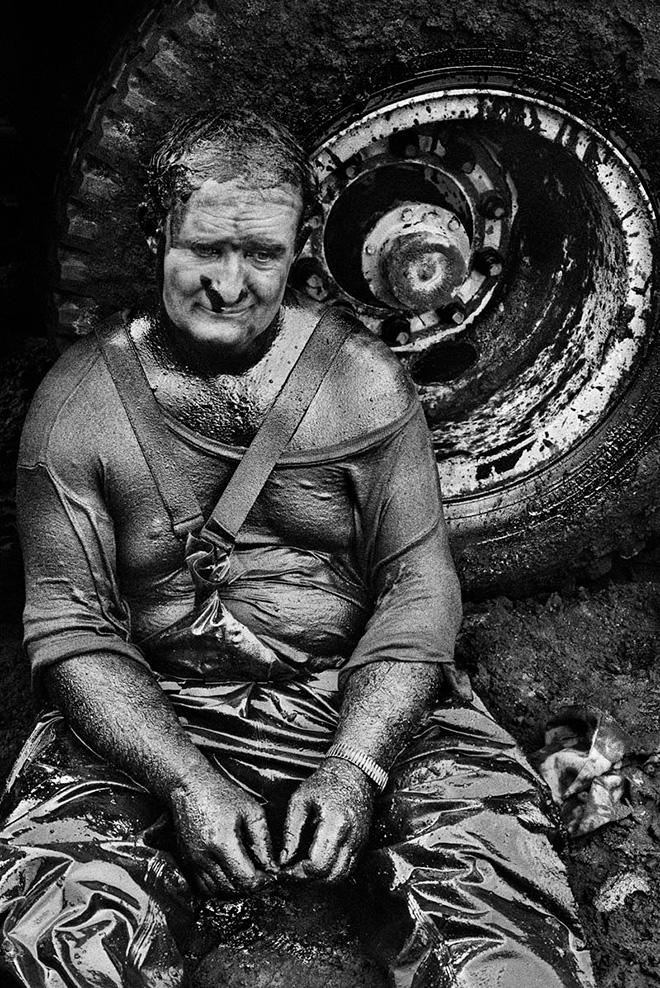 SEBASTIÃO SALGADO - Kuwait after the end of the Gulf War - The oil fields continue to burn, causing a massive ecological disaster and large loss of money. Oil-well fire fighters from around the globe at work to put out the burning oil wells. Worker of the Safety Boss Company during a rest, 1991
Il Kuwait dopo la fine della Guerra del Golfo - I pozzi petroliferi continuano a bruciare, causando un massiccio disastro ecologico e una grande perdita di denaro. Compagnie di pompieri specializzati, provenienti da tutto il mondo, a lavoro per estinguere il fuoco. Operaio della Safety Boss Company durante una pausa, 1991 © Salgado/AmazonasImages/Contrasto