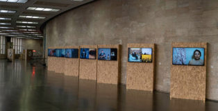 Mustafa Sabbagh, anthro-pop-gonia, 2015. installazione audio-video: 7 video HD su 7 schermi lcd, color, loop, dimensioni ambientali. veduta di Station to Station, Salone dei Mosaici di Messina Marittima