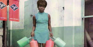 James Barnor – Sick-Hagemeyer shop assistant with bottles, taken as a colour guide, Accra, (detail) 1971 Stampa cromogenica © James Barnor/Autograph ABP, London.