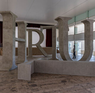 Shilpa Gupta, Truth, 2025 Legno, resina, cemento, Dimensioni totali: 14,50 x 8 m | 570.86 x 314.96 in, T: 327 x 405 x 75 cm | 128.74 x 159.44 x 29.52 in; H: 405 x 401 x 75 cm | 159.44 x 157.87 x 29.52 in; R: 265 x 401 x 75 cm | 104.33 x 157.87 x 29.52 in; U: 398 x 409 x 75 cm | 159.69 x 161.02 x 29.52 in; T: 327 x 405 x 75 cm | 129.74 x 159.44 x 29.52 in, Courtesy: l’artista e GALLERIA CONTINUA. Fotografa: Ela Bialkowska, OKNO Studio Shilpa Gupta, Galleria Continua / San Gimignano