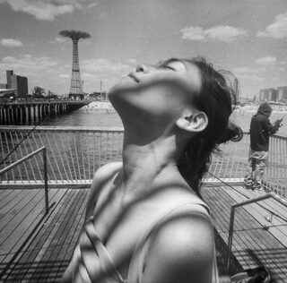 © Harvey Stein (USA) - Woman on Coney Island Pier Looking Skyward from the series 'Coney Island People 50 Years'. 1st place winner AAP Magazine #47: Shadows All About Photo – AAP Magazine #47: Shadows