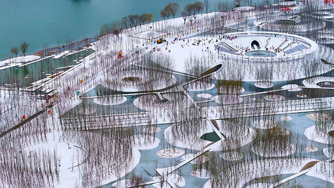 Turenscape Turenscape - Sponge Synergy: The Huaiyang Fuxi Cultural Park, Henan, China. Winter transforms the crater island landscape into a picturesque arena for skiing and ice skating. Photo credit: Turenscape