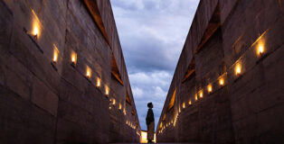 Atiaîa Lighting Design - Memorial Brumadinho. The ipê flowers guide the path downwards the viewpoint. The lighting effect is subtle but enough to highlight the jagged walls. Photo credit: Leo Drumond/Nitro