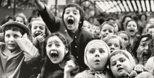 Alfred Eisenstaedt - Al teatro delle marionette delle Tuileries, un gruppo di bambini assiste alla rappresentazione di “San Giorgio e il Drago”. La foto è del momento in cui il drago viene ucciso Parigi, 1963 . © Alfred Eisenstaedt / The LIFE Picture Collection / Shutterstock